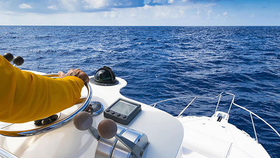 A sky view of a boat slicing through waves on lake