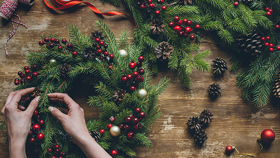A person decorating a wreath