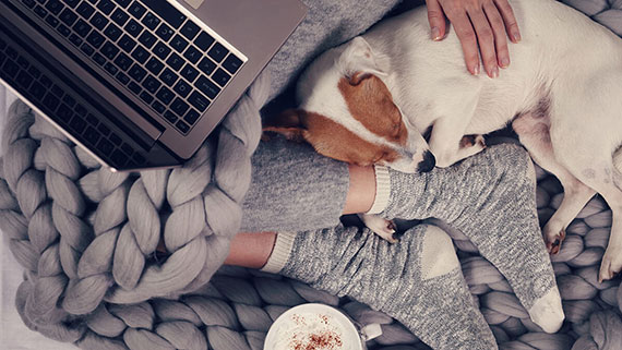 A mug of hot chocolate next to comfy socks and blanket.