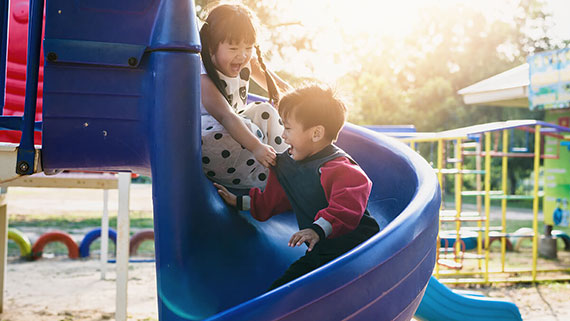 A girl climbing up monkey bars at playground