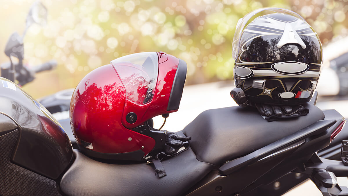 A motorcycle helmet hanging off motorcycle handle bar