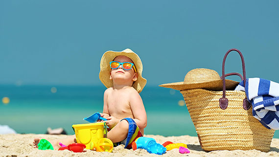 A water bottle near a towel and beach chair on the beach