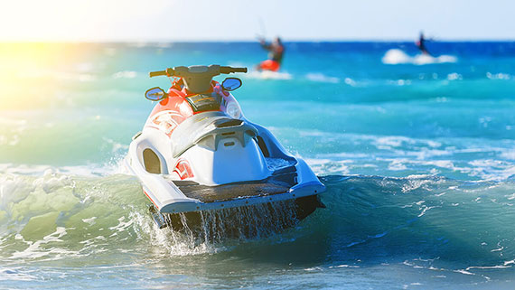 A couple of personal watercraft riders jetting over lake