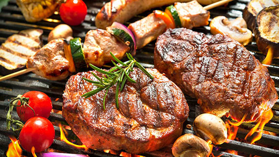 A joyful family surrounding the outside grill
